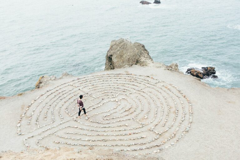 Une personne face a un labyrinthe tracé avec des cailloux. Cela représente un accompagnement de coaching individuel